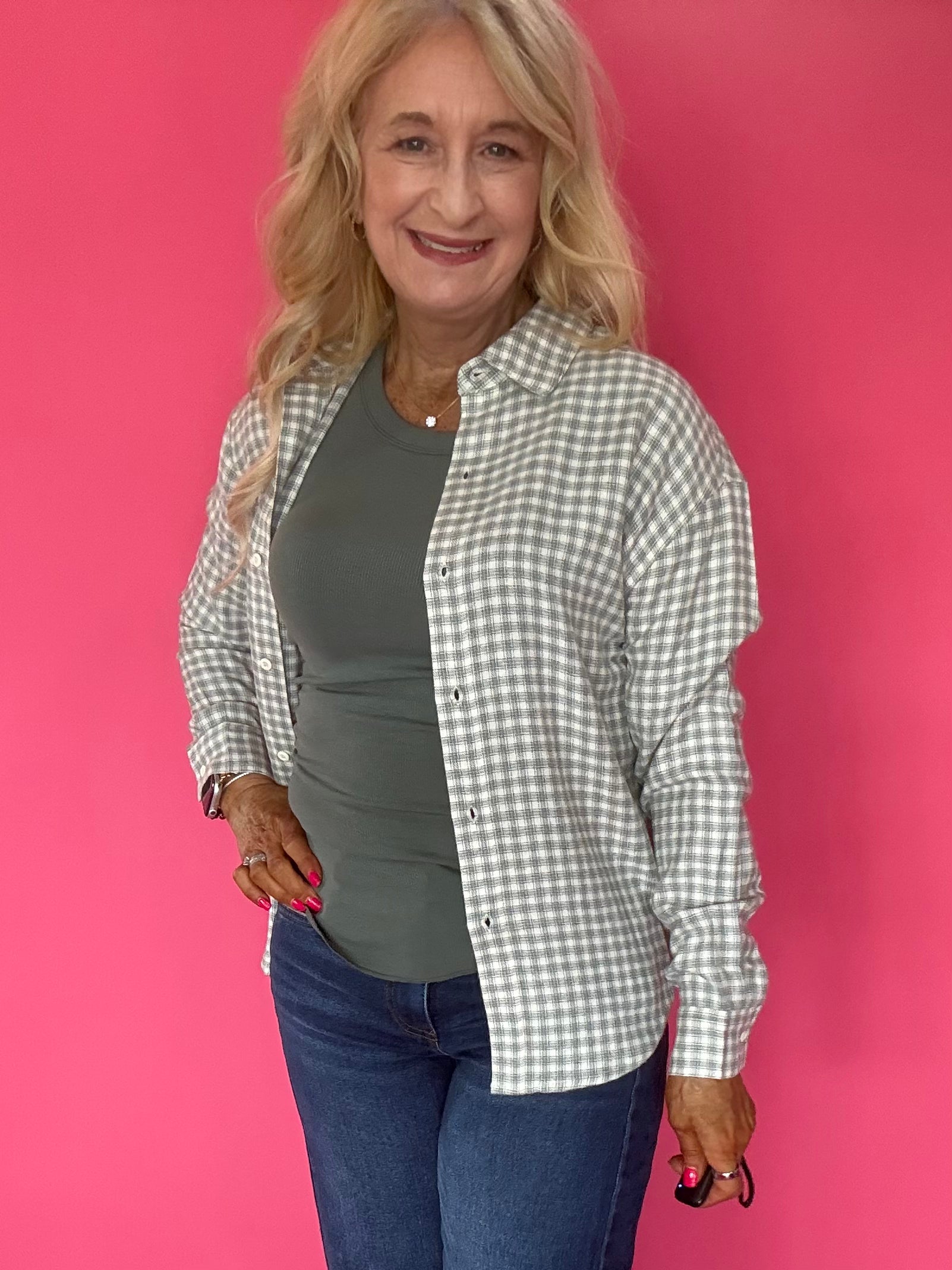 Side view of the green ribbed tank layered under an open cardigan with denim for fall