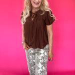 Close-up of the clean neckline and soft lightweight woven fabric on the brown everyday blouse
