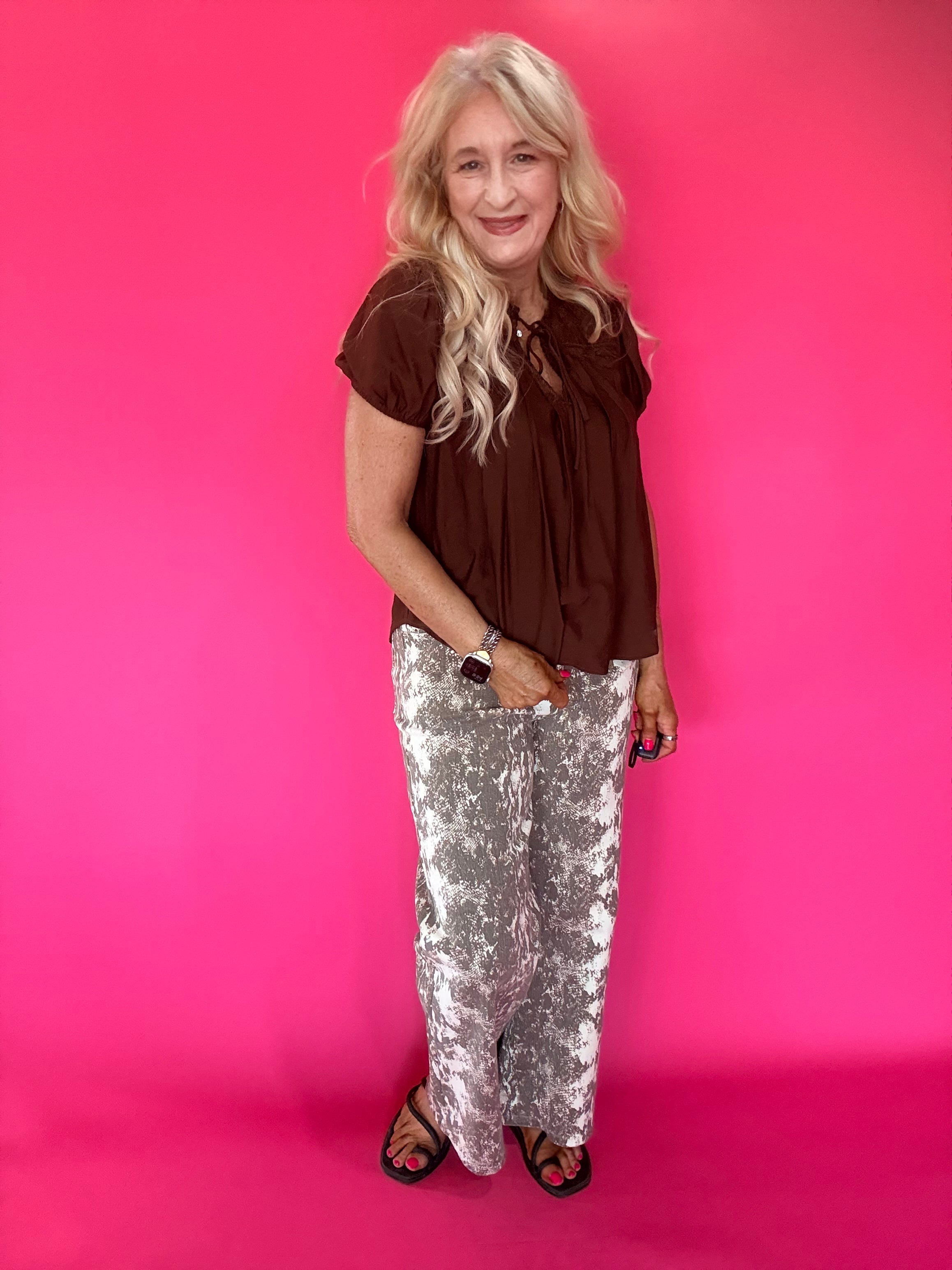 Side view showing the sleeve and easy relaxed shape of the brown lightweight woven blouse