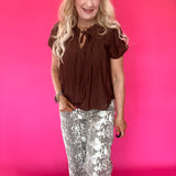 Brown woven blouse layered under a blazer with tailored trousers for a polished office look