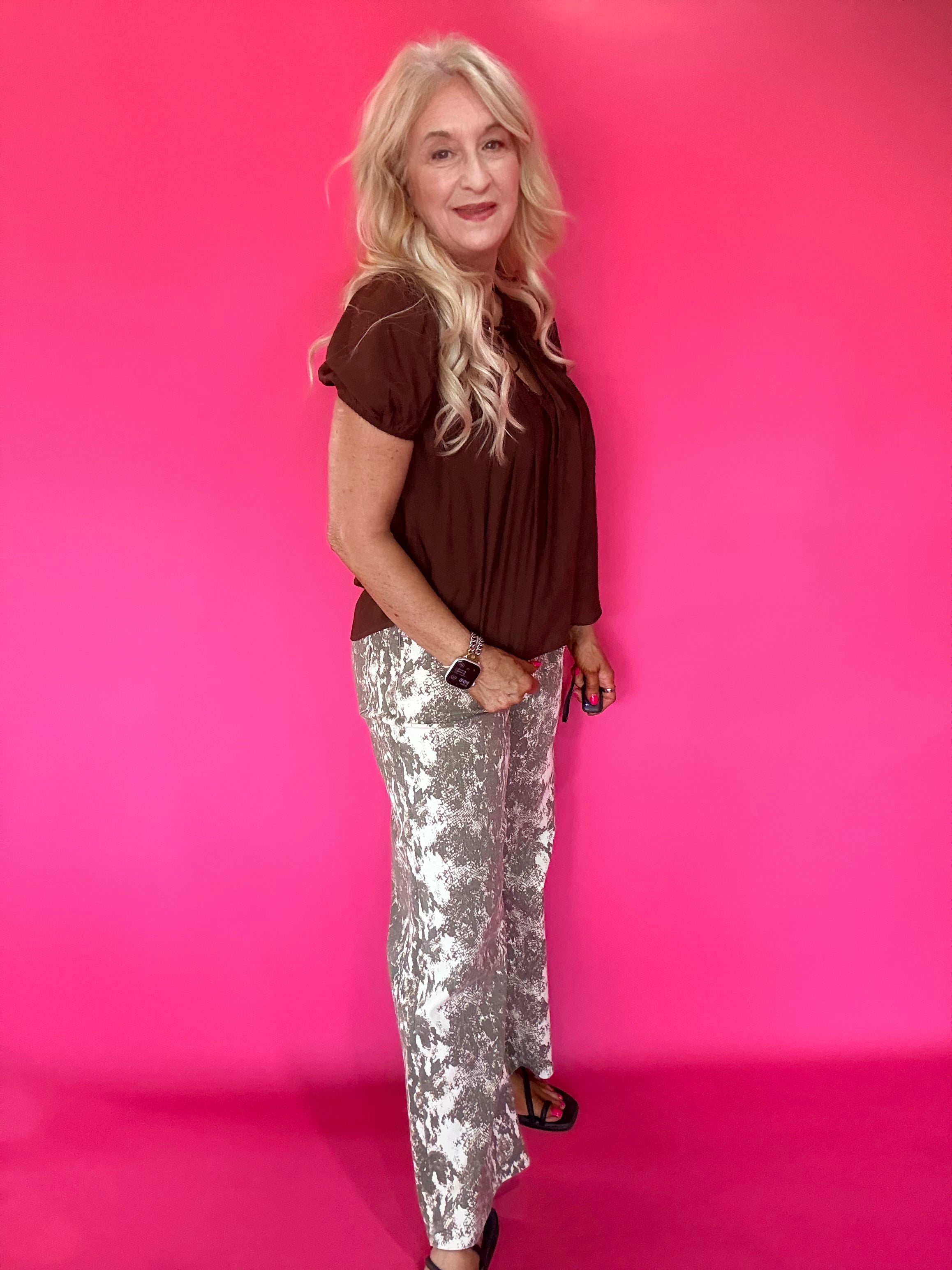 Full length view of the lightweight brown woven blouse tucked into high waisted denim