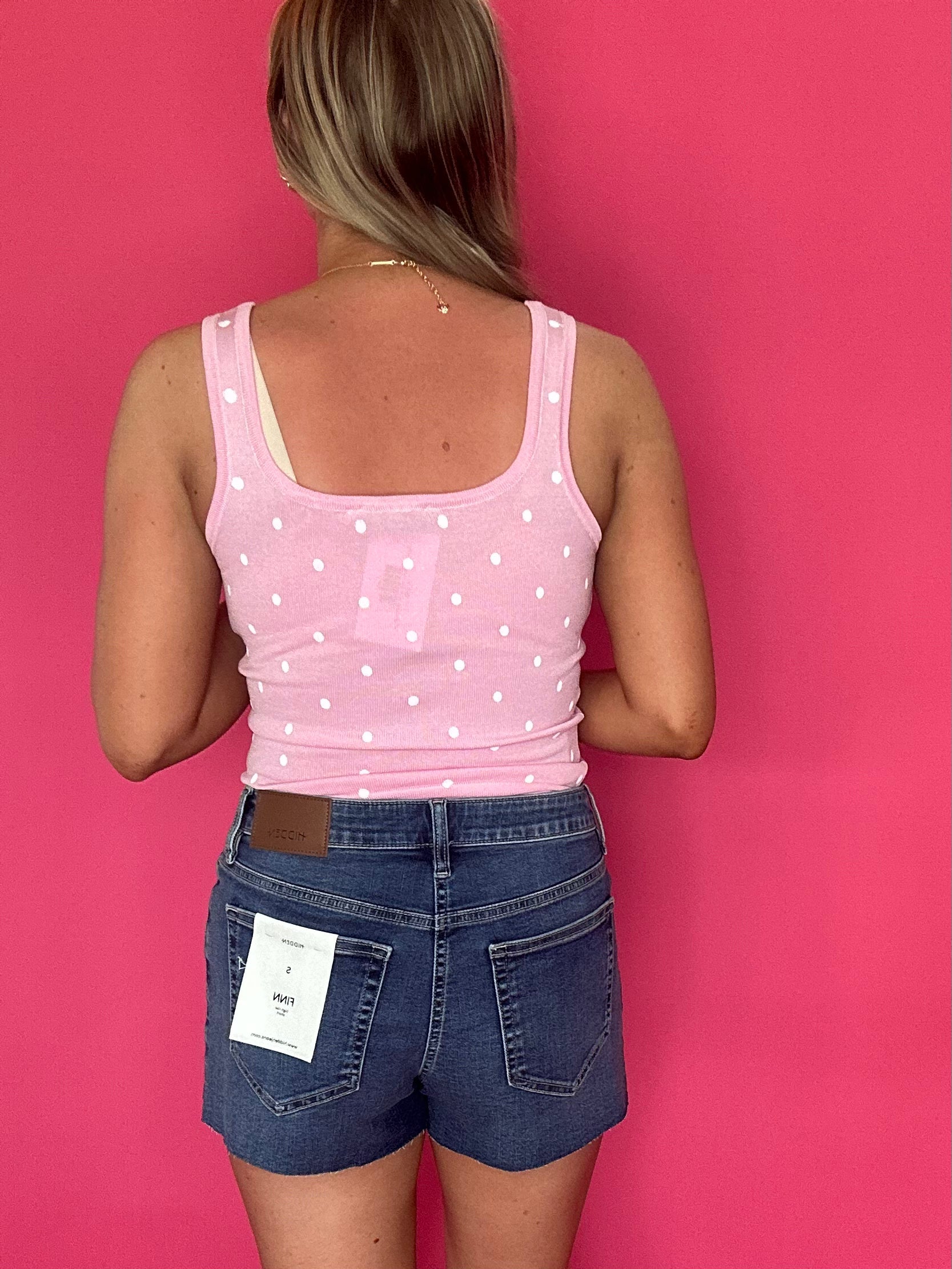 Flat lay of the medium dark wash high rise denim shorts showing the raw hem and pockets