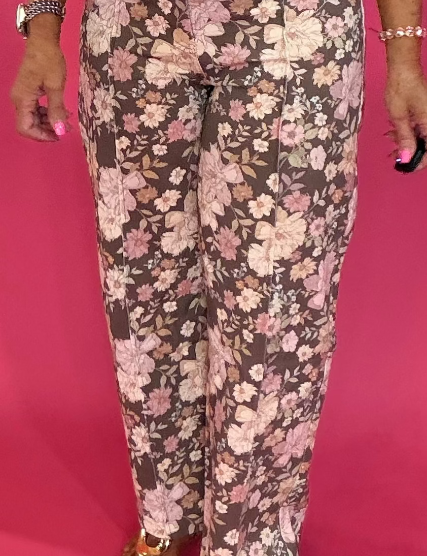 Woman wearing brown floral print wide leg pants with a fitted solid tee and sandals