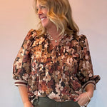 Woman wearing a floral print peplum blouse with a tie front closure and three-quarter sleeves