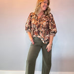 Back view of the floral print peplum blouse showing the cinched waist and flared peplum hem