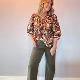 Back view of the floral print peplum blouse showing the cinched waist and flared peplum hem