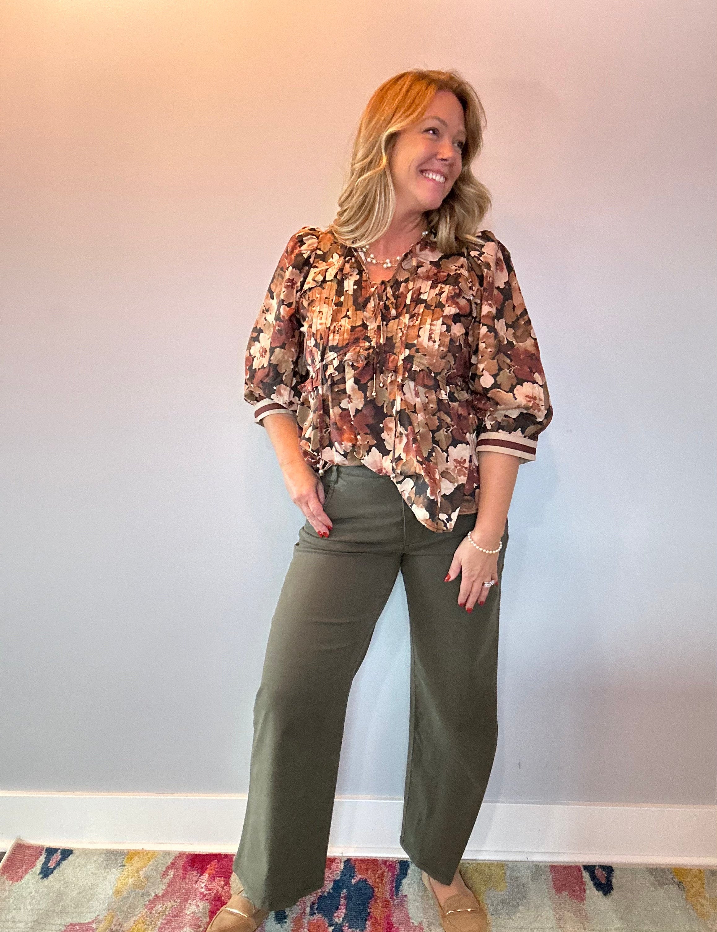 Back view of the floral print peplum blouse showing the cinched waist and flared peplum hem