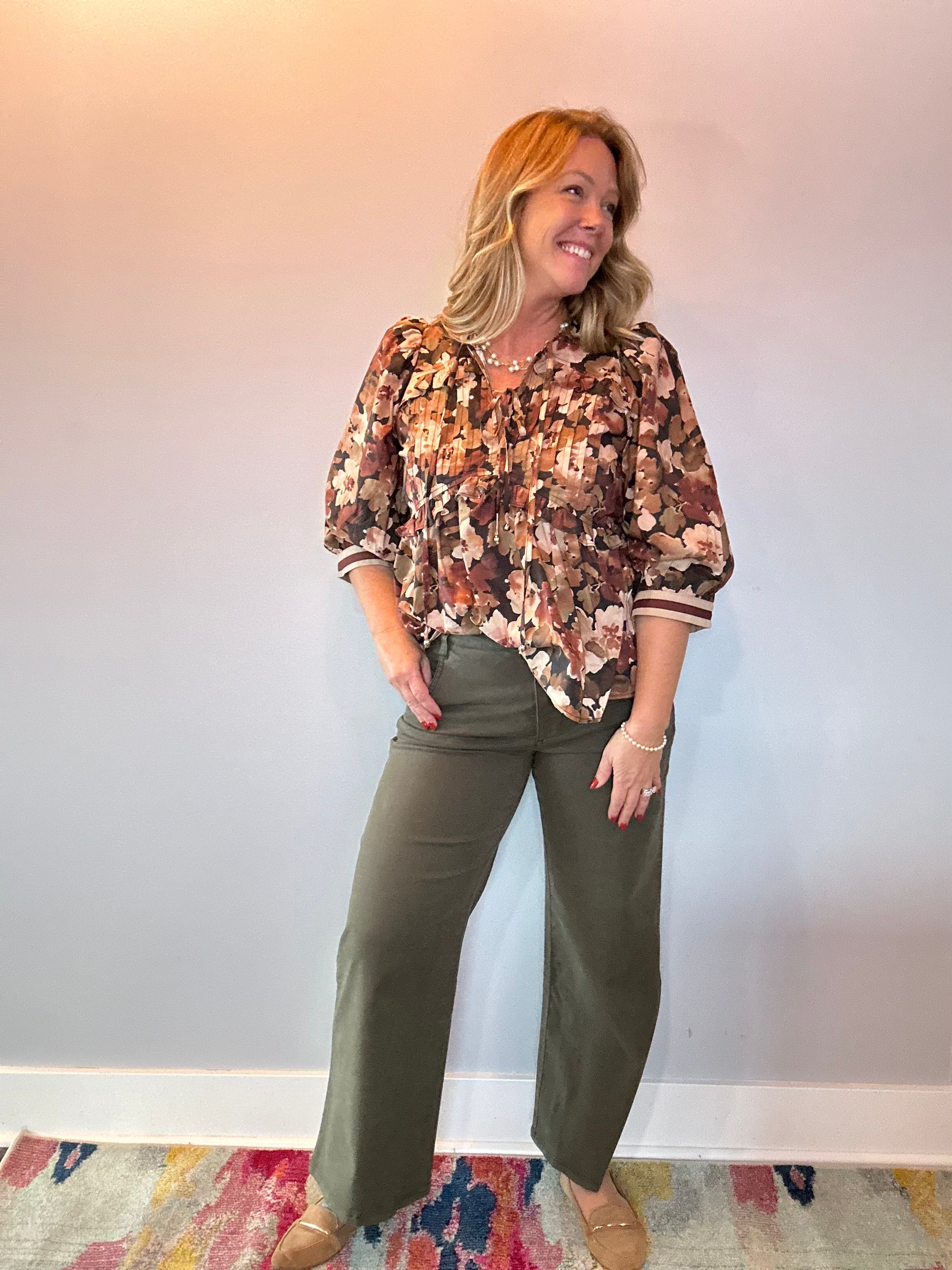 Back view of the floral print peplum blouse showing the cinched waist and flared peplum hem