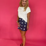 Flat lay of the fully lined navy polka dot satin mini skirt laid out to show the drape