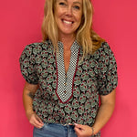 Woman wearing a deep green lightweight woven top with a subtle allover print and relaxed fit