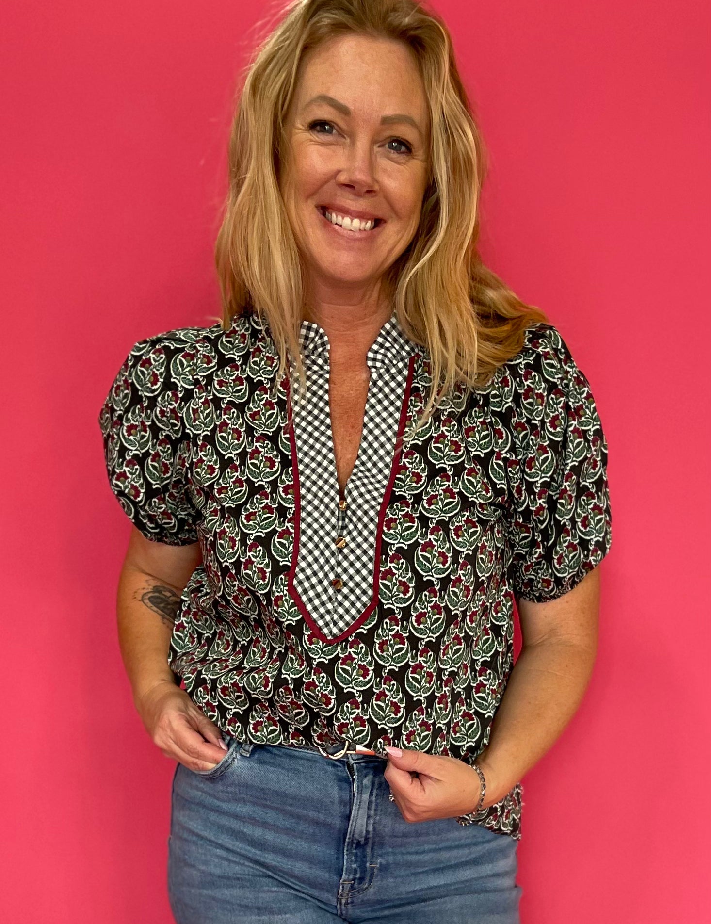 Woman wearing a deep green lightweight woven top with a subtle allover print and relaxed fit
