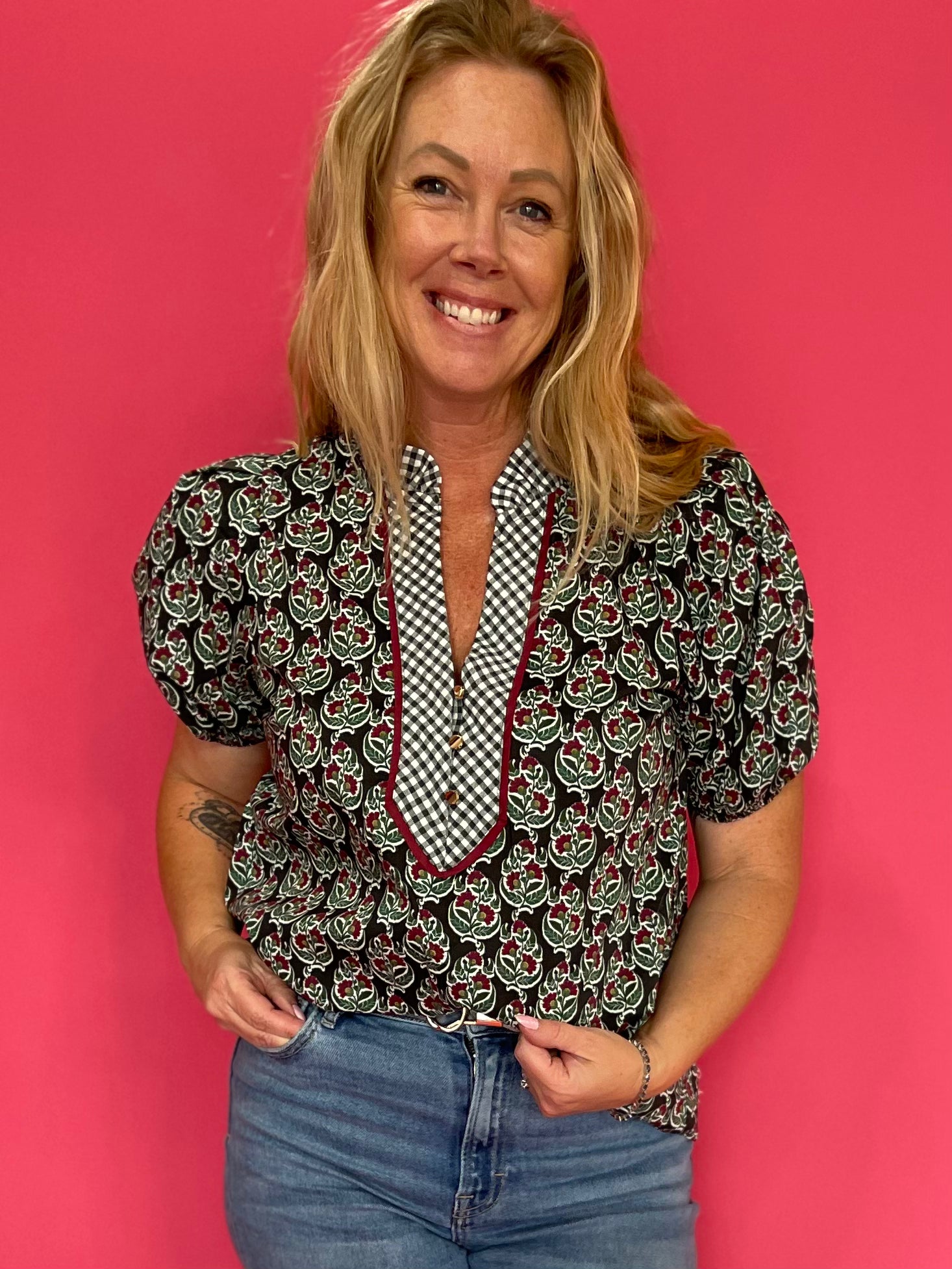 Woman wearing a deep green lightweight woven top with a subtle allover print and relaxed fit