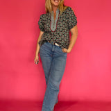 Detail of the neckline and shoulder on the dark green printed relaxed fit woven everyday top