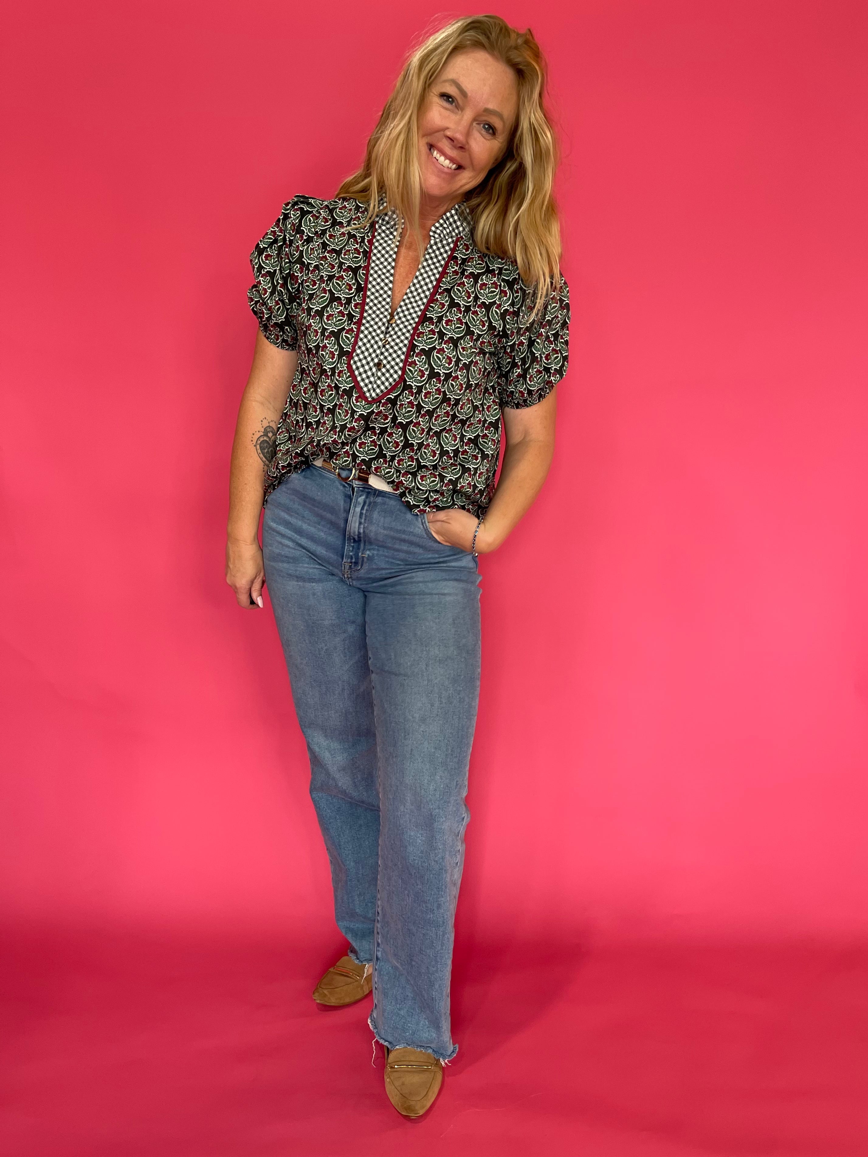 Side view of the deep green printed top worn tucked into high waisted denim for fall days