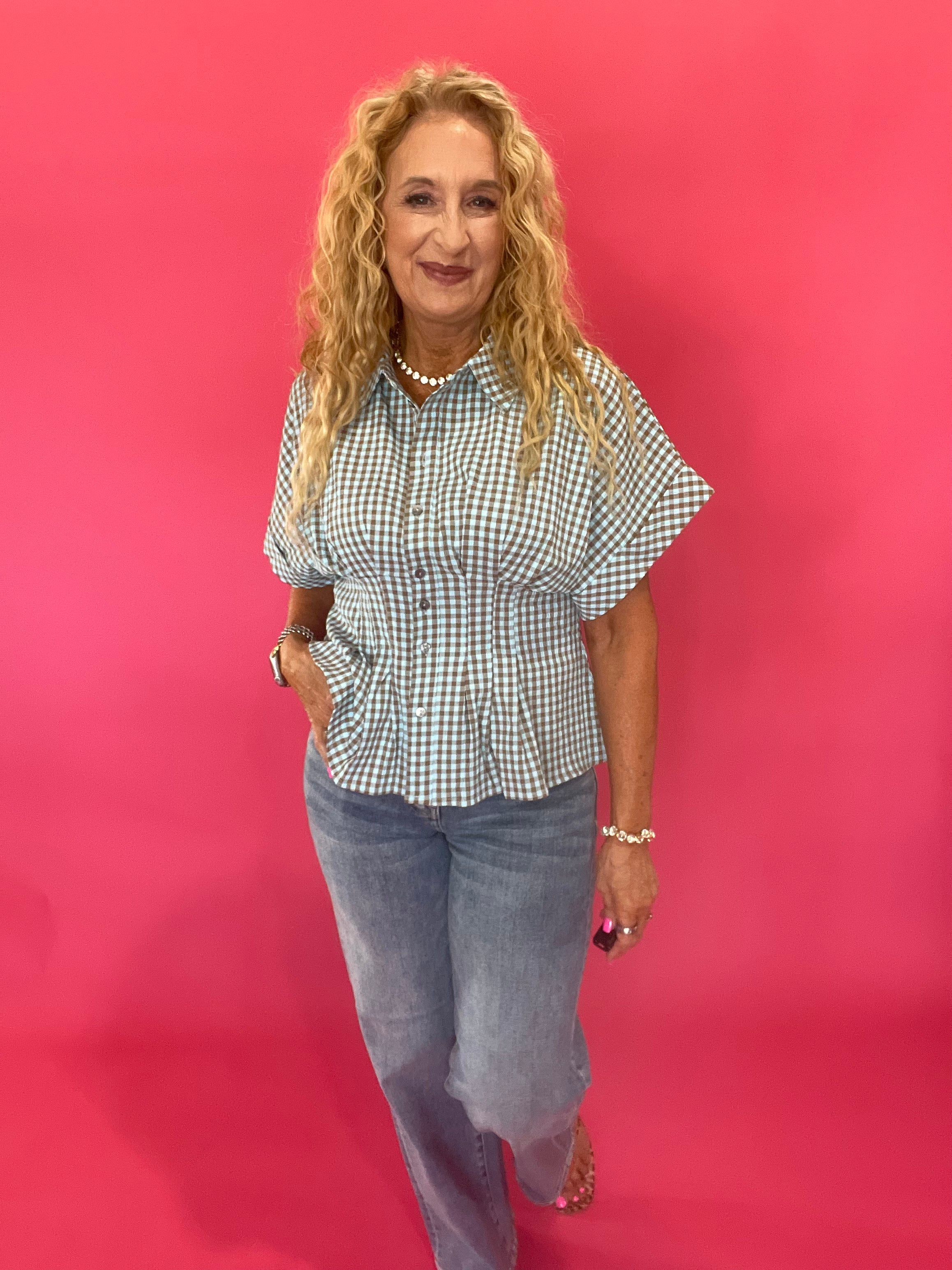 Close-up of the brown gingham top tucked into the medium wash mid rise dad jeans at the waist