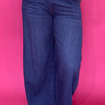 Woman wearing dark wash high rise wide leg trouser jeans with a clean non distressed hem