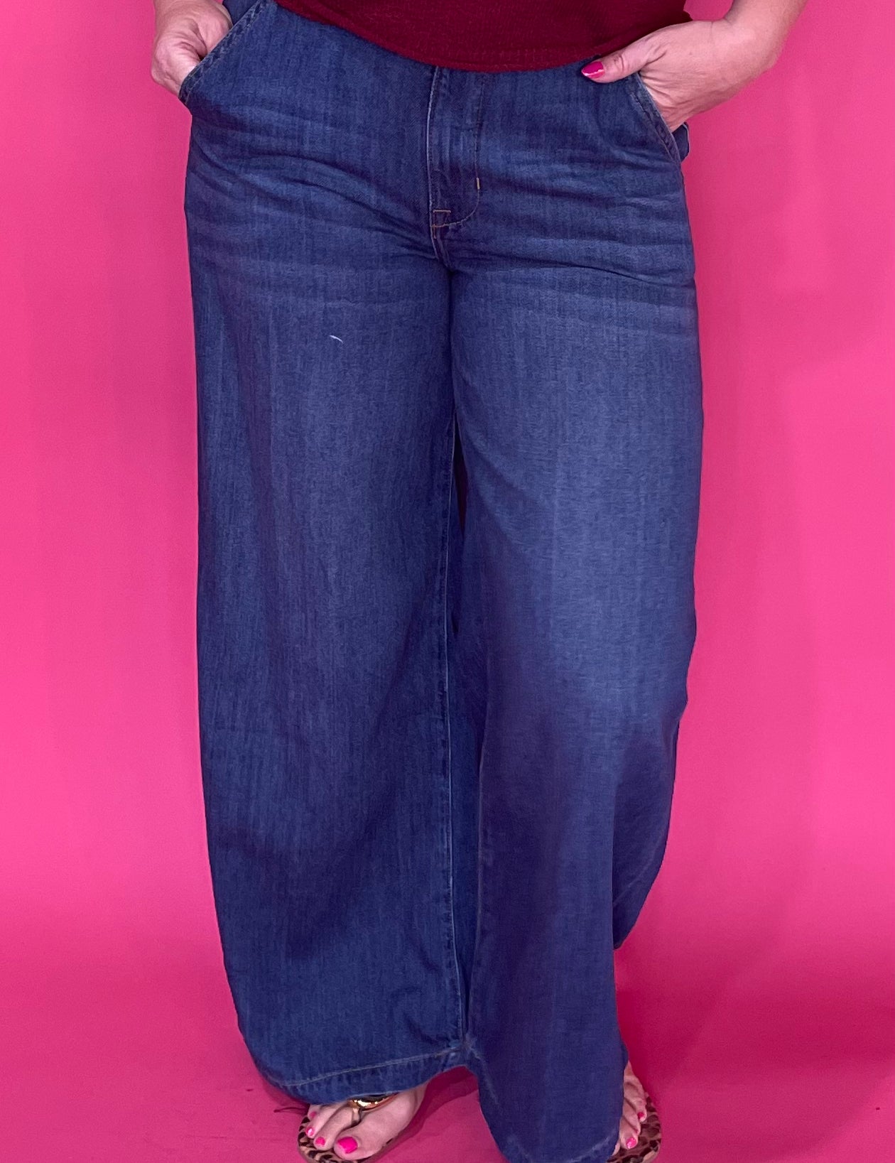 Woman wearing dark wash high rise wide leg trouser jeans with a clean non distressed hem