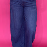 Woman wearing dark wash high rise wide leg trouser jeans with a clean non distressed hem