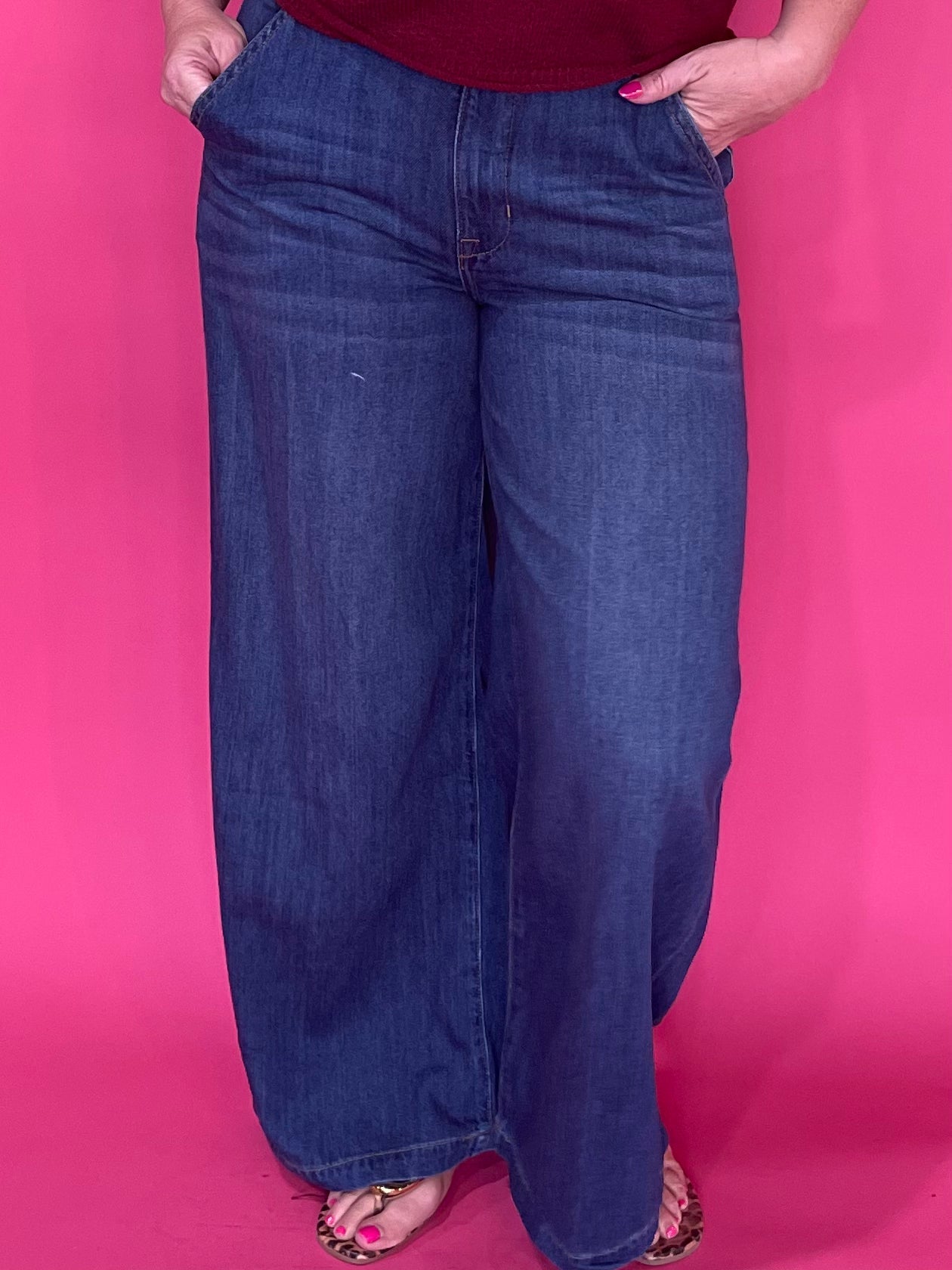Woman wearing dark wash high rise wide leg trouser jeans with a clean non distressed hem