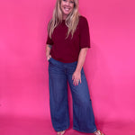 Back view of the dark wash high rise wide leg trouser jeans showing the long straight leg line