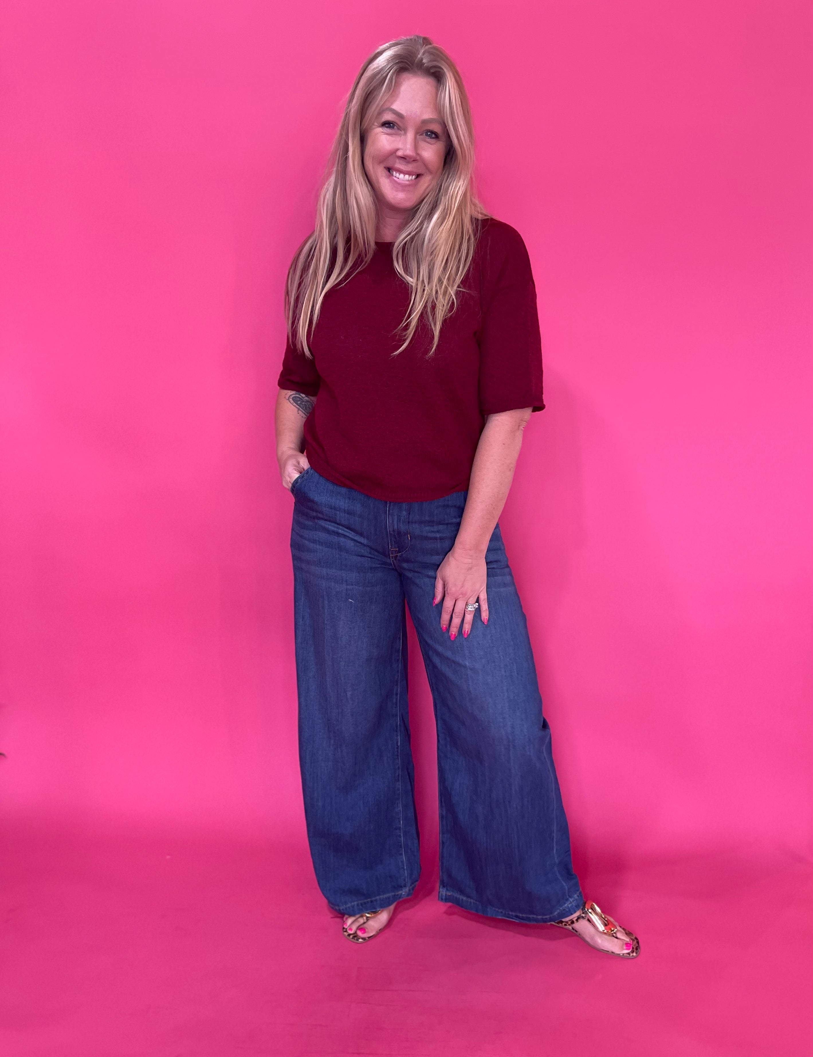 Back view of the dark wash high rise wide leg trouser jeans showing the long straight leg line