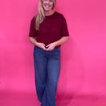 Close-up of the front fly zipper and button closure on the dark wash high rise trouser jeans