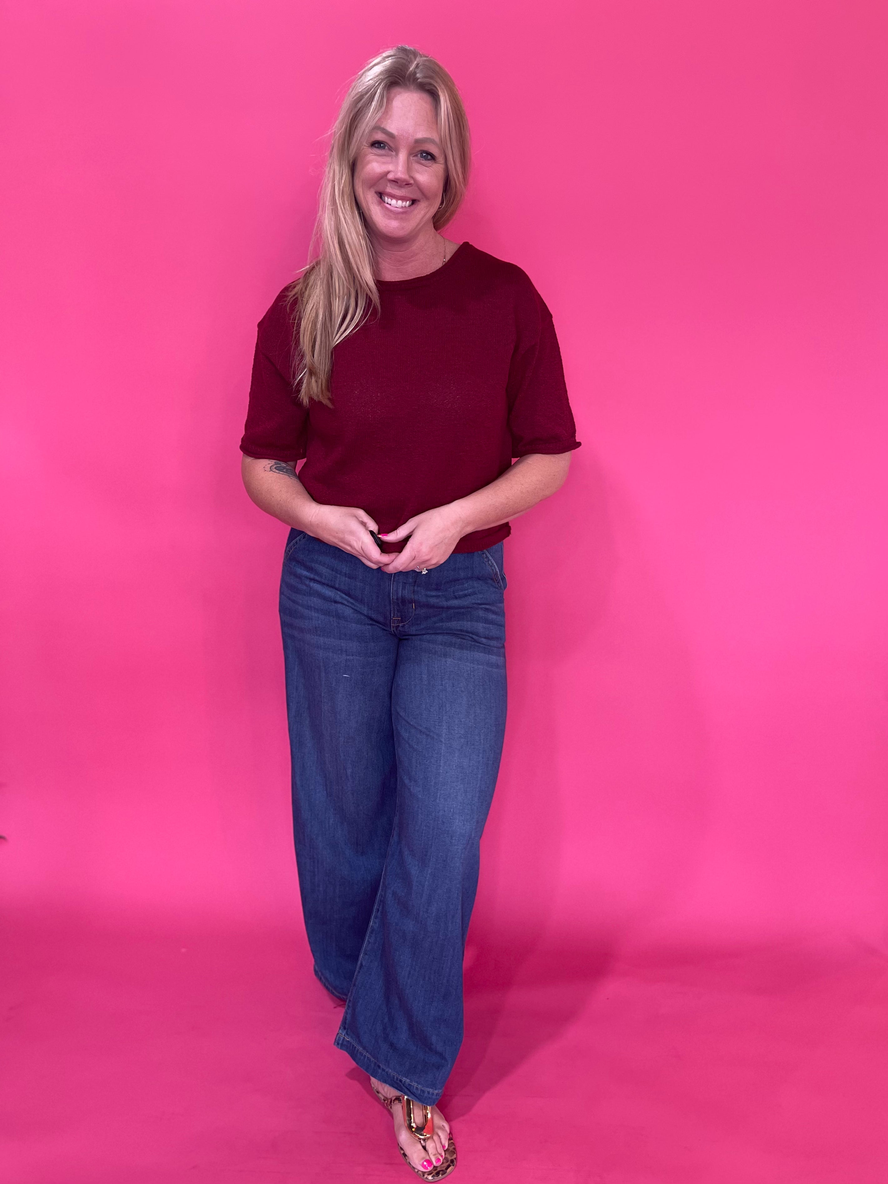 Close-up of the front fly zipper and button closure on the dark wash high rise trouser jeans