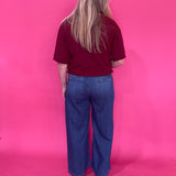 Side view of the high rise dark wash wide leg denim trouser showing the full length leg drape