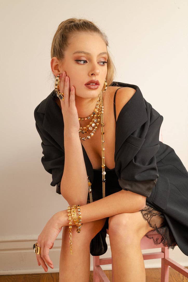 Flat lay of the mixed metal Izzy stretch bracelet shown on a plain neutral background