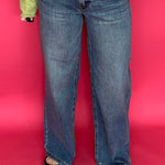 Woman wearing high rise wide leg jeans with a clean hem styled with a fitted tee tucked in