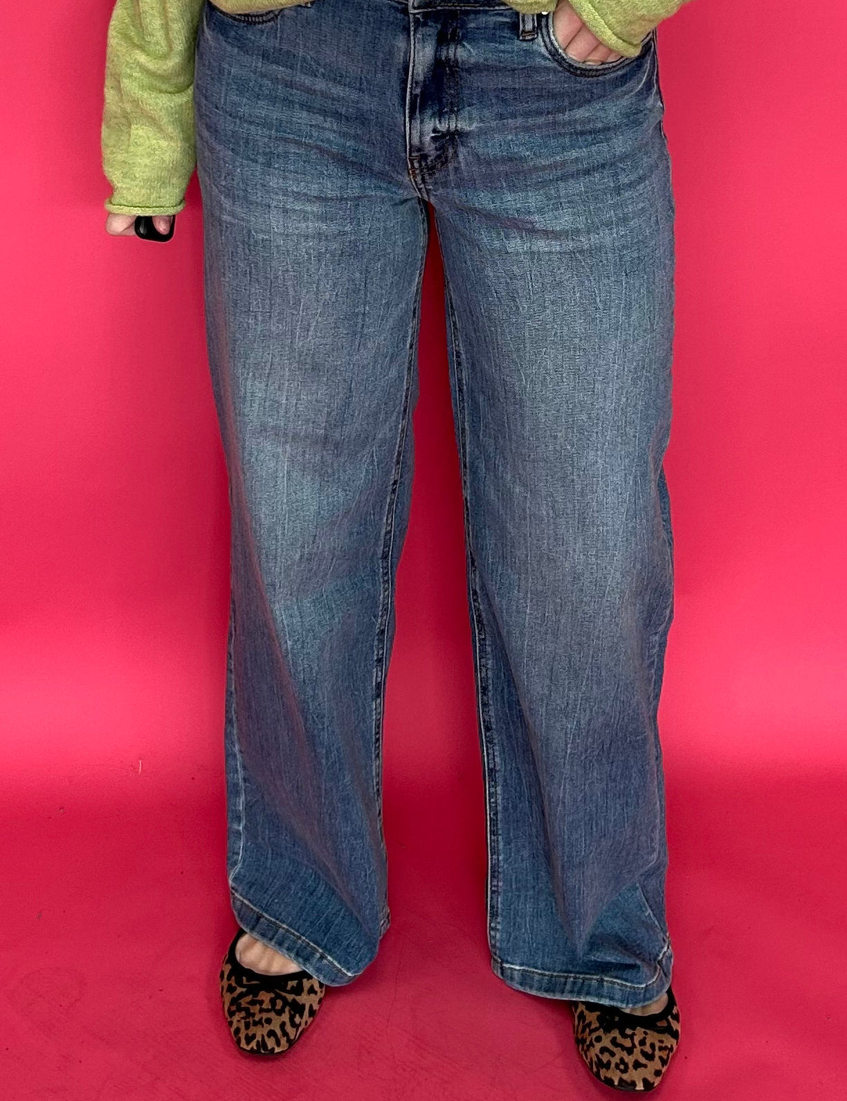 Woman wearing high rise wide leg jeans with a clean hem styled with a fitted tee tucked in
