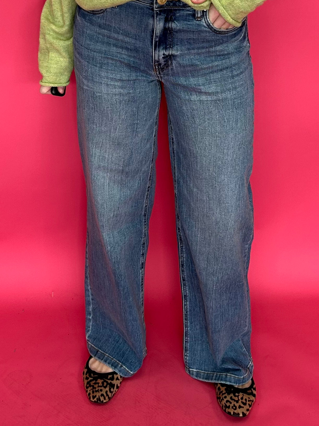 Woman wearing high rise wide leg jeans with a clean hem styled with a fitted tee tucked in