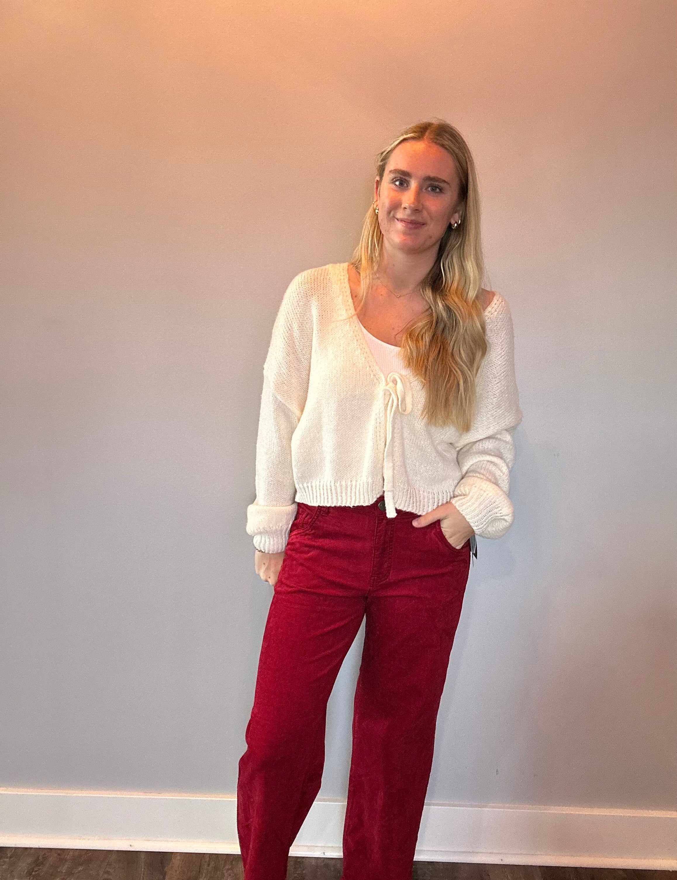 Back view of the red velveteen flare pants showing the high rise waist and long leg line