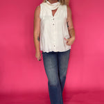 Back view of the cream sleeveless top showing the light breezy drape through the body