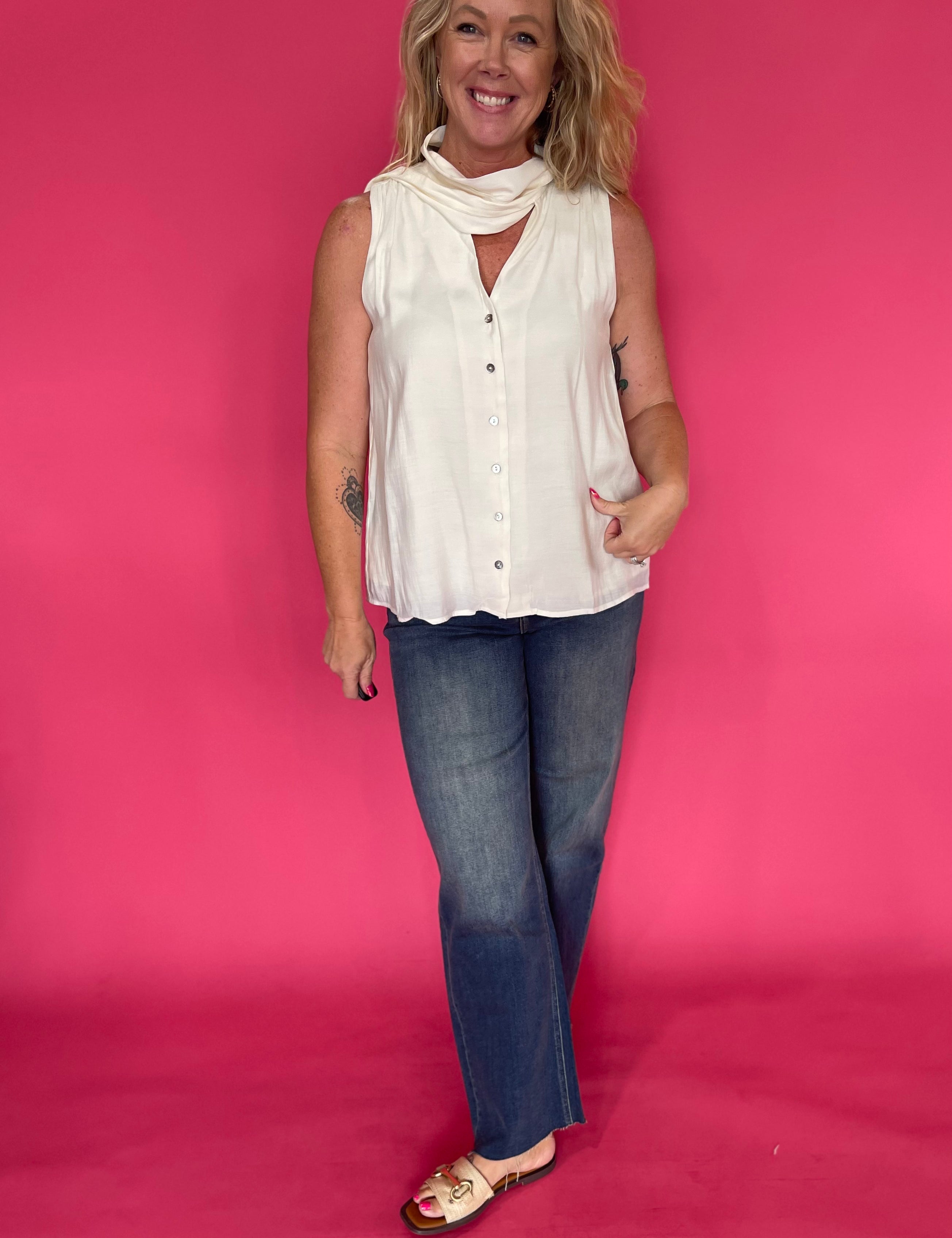 Back view of the cream sleeveless top showing the light breezy drape through the body