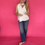 Side view of the cream top layered under an open blazer with tailored trousers for work