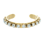 Open antique gold cuff bracelet lined with blue crystals, shown worn on a model's wrist