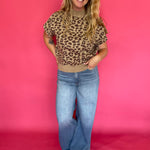 Close-up of the leopard print knit and solid ribbed hem on the cap sleeve knit top