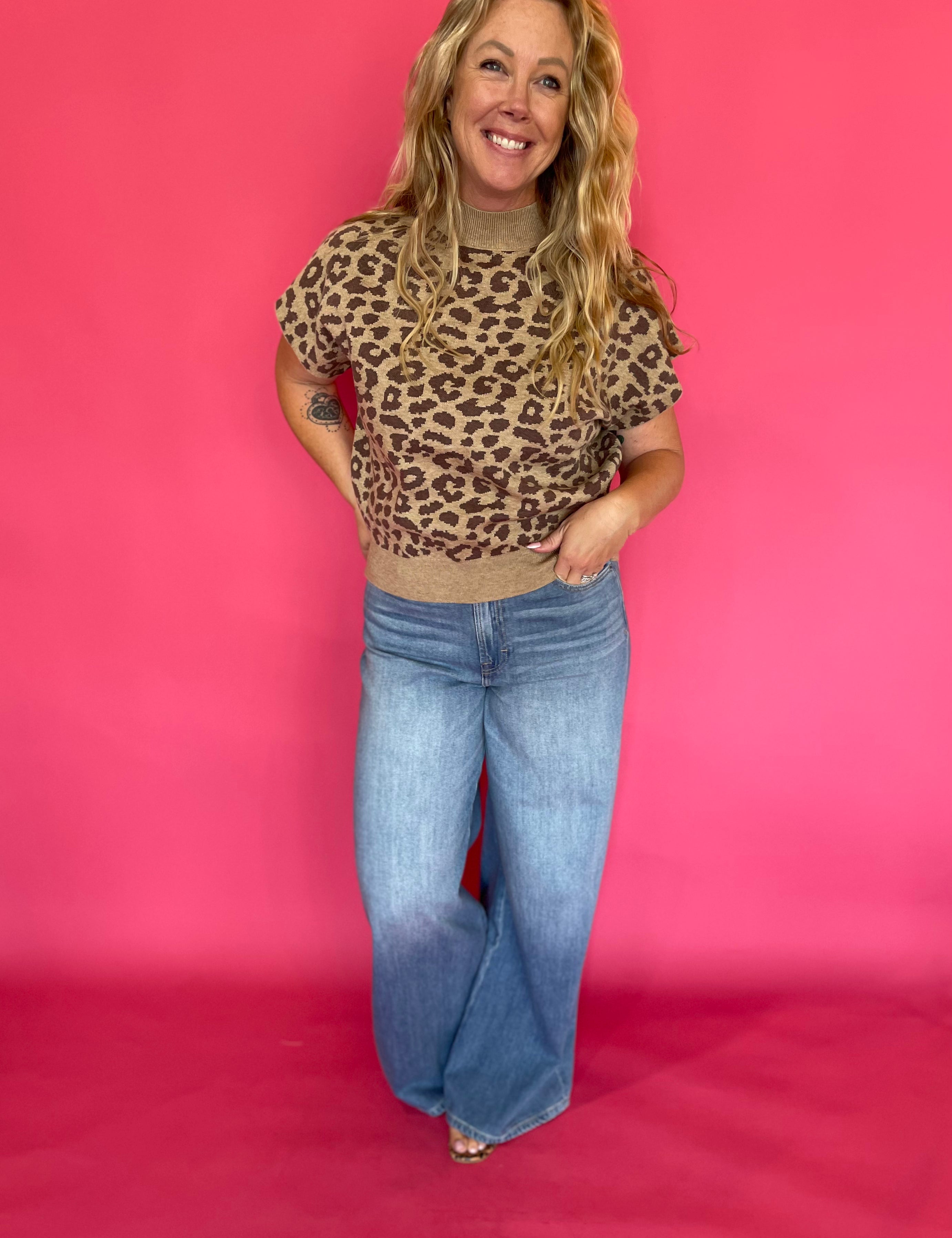 Close-up of the leopard print knit and solid ribbed hem on the cap sleeve knit top