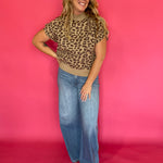 Leopard print knit top tucked into dark denim with gold jewelry for an evening look