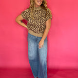 Leopard print knit top tucked into dark denim with gold jewelry for an evening look