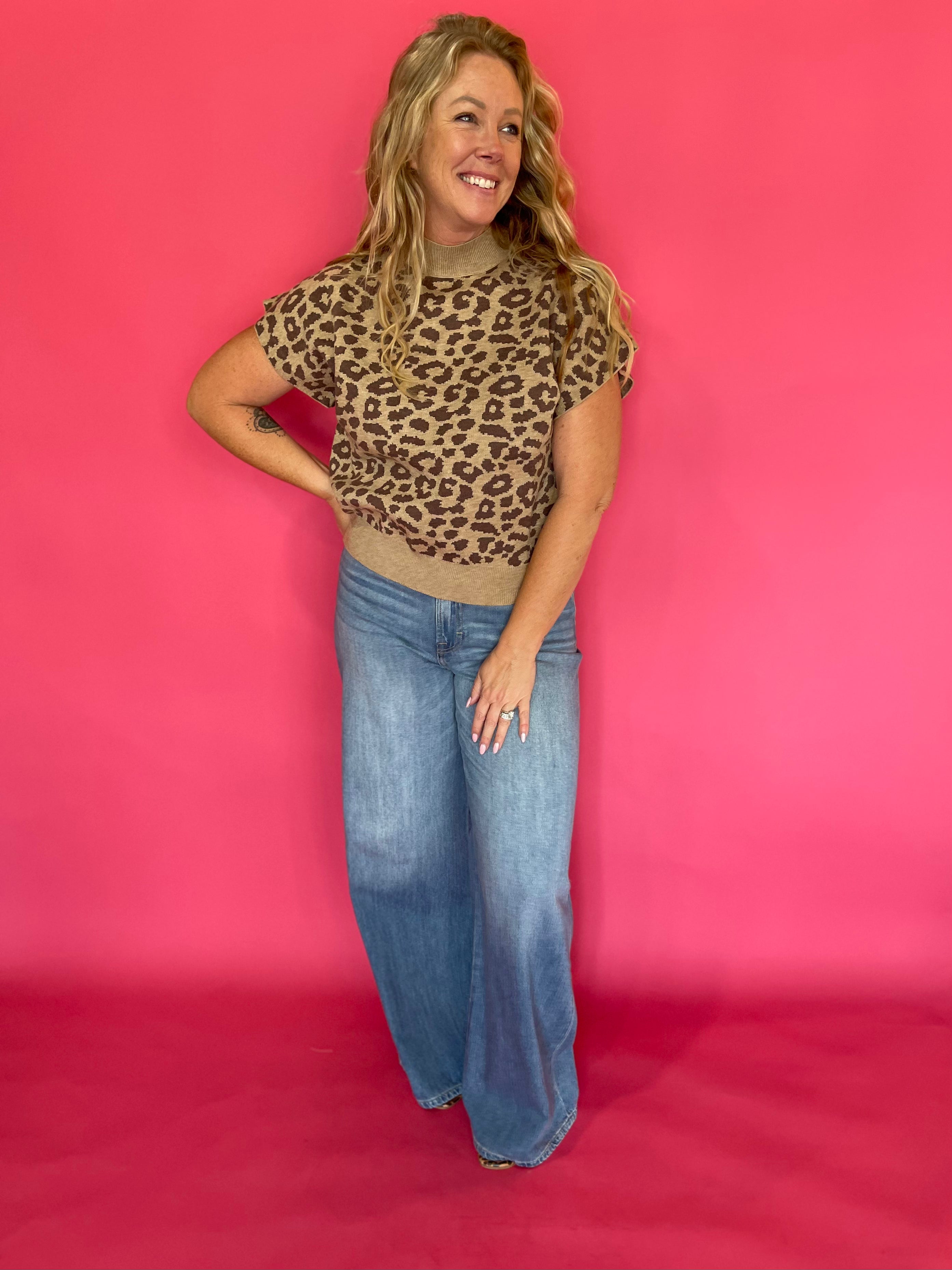 Leopard print knit top tucked into dark denim with gold jewelry for an evening look