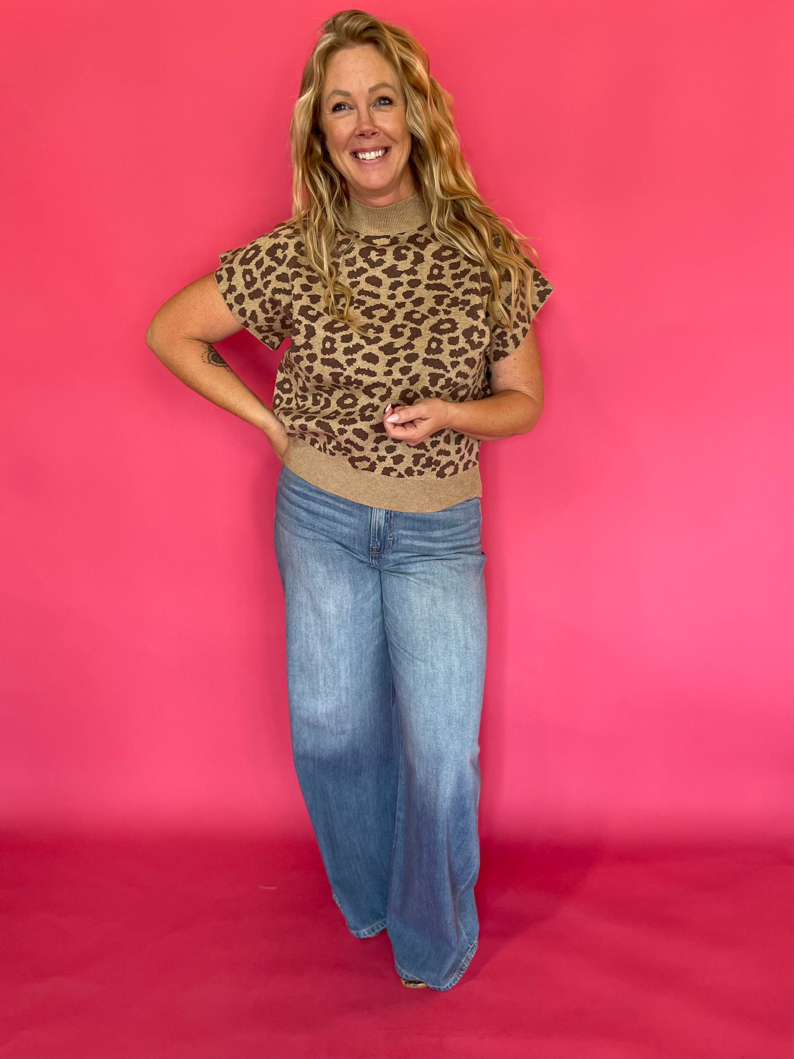 Side view of the leopard print knit top showing the extended cap sleeve shoulder coverage