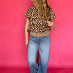 Full length view of the leopard print knit top with its mock neck and extended cap sleeves