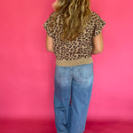 Detail of the solid ribbed hem band at the bottom of the leopard print cap sleeve knit top