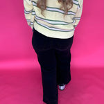 Full length view of the black high rise wide leg jeans styled with a fitted top for dinner