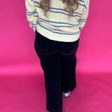 Full length view of the black high rise wide leg jeans styled with a fitted top for dinner
