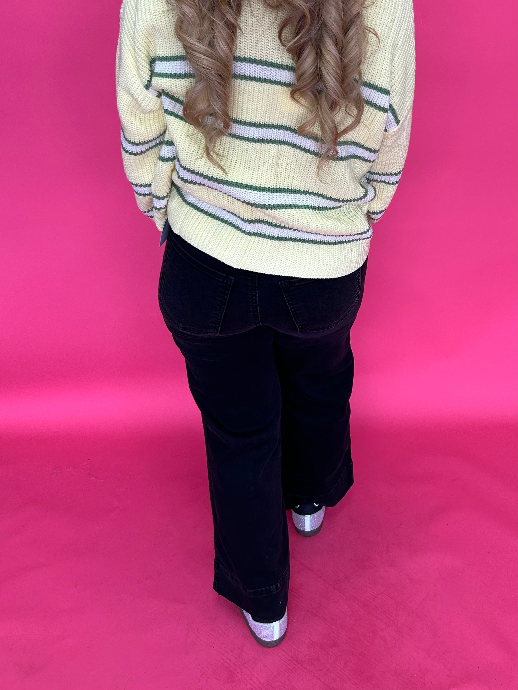 Full length view of the black high rise wide leg jeans styled with a fitted top for dinner