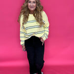 Side view of the black wide leg jeans styled with ankle boots for a polished look