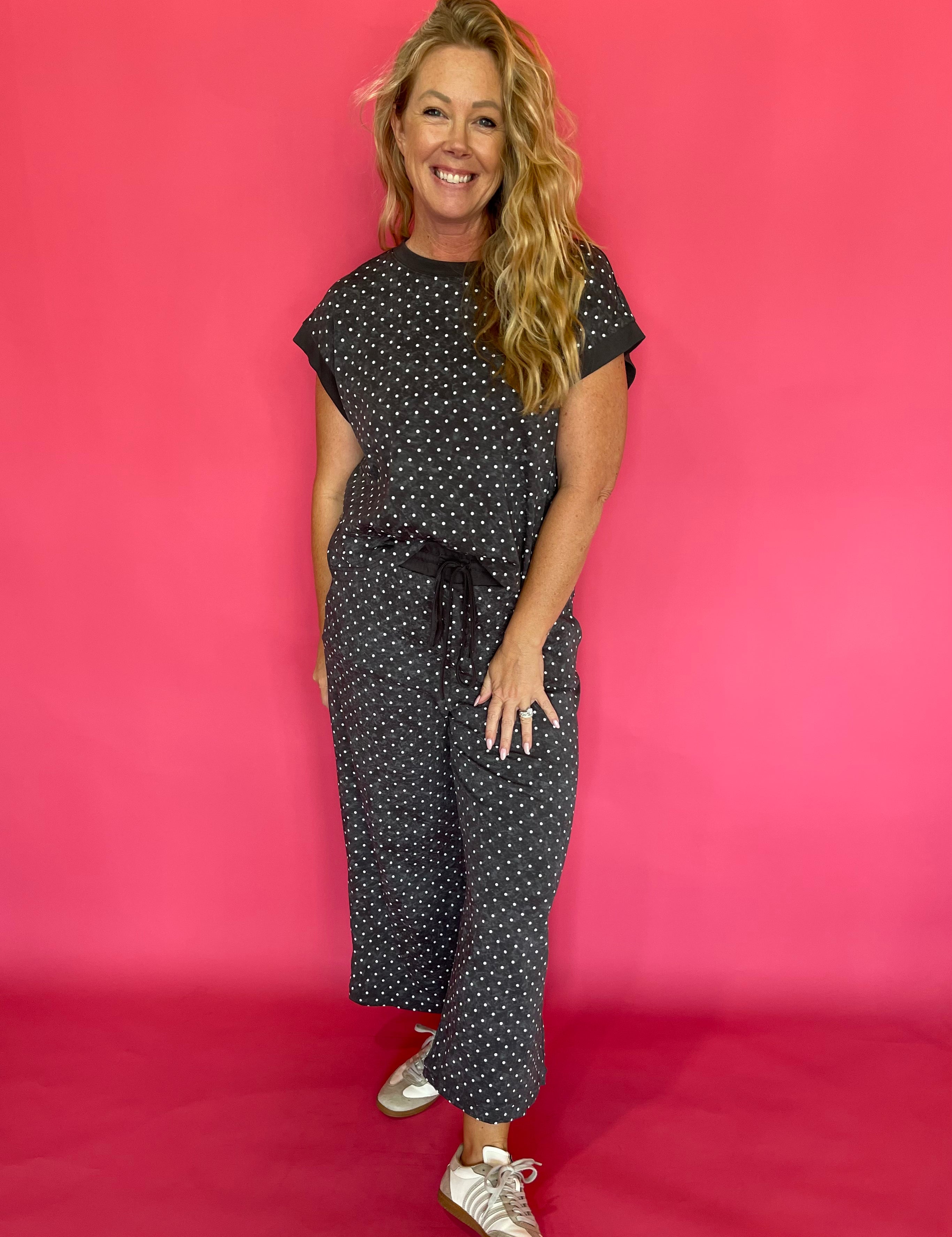Back view of the charcoal polka dot scuba two piece set showing the relaxed cap sleeve top